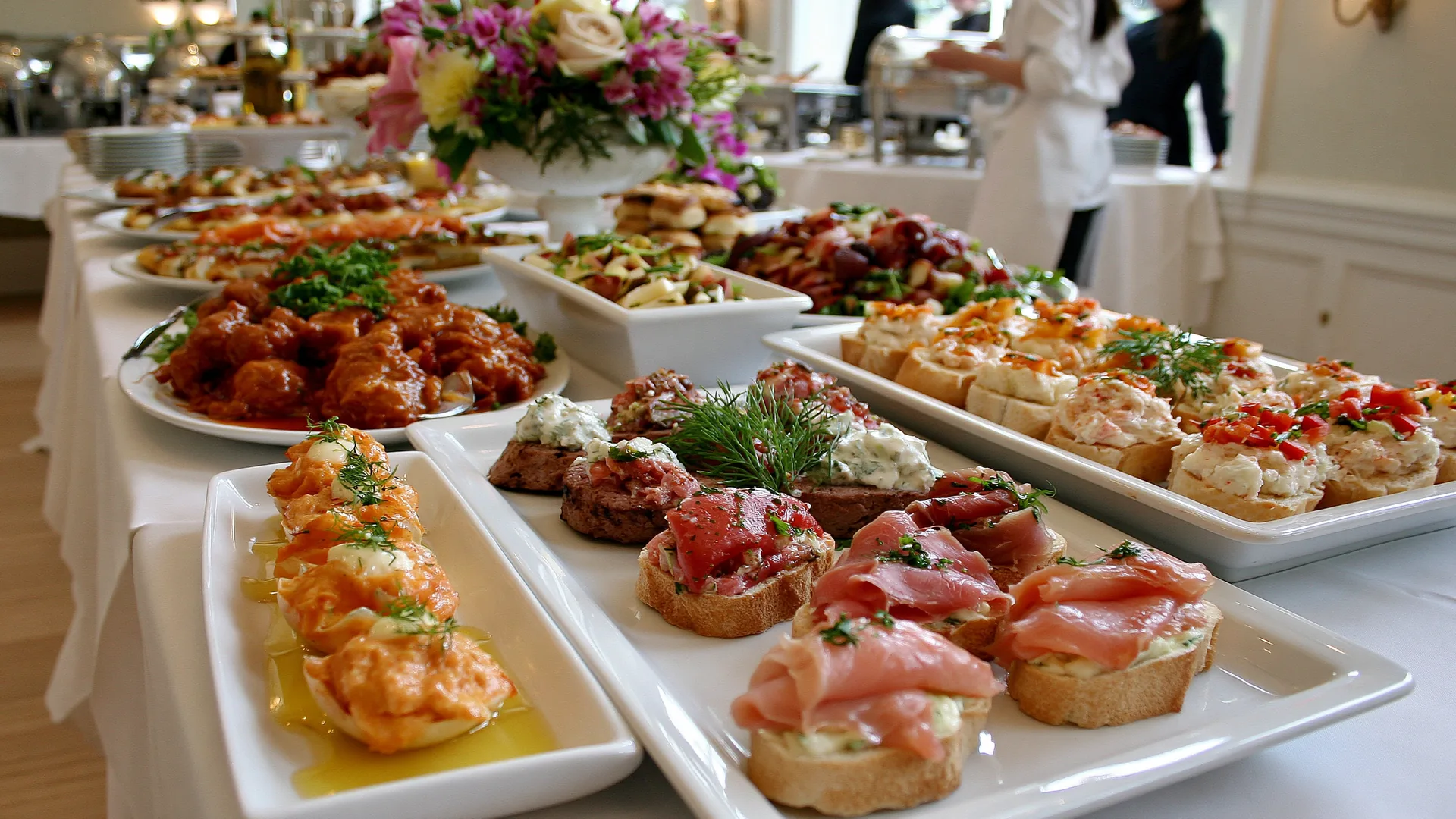 Mesa de evento con bocados y flores
